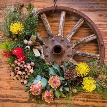 Altes Rad als Alternative zum Kranz mit Herbstblumen