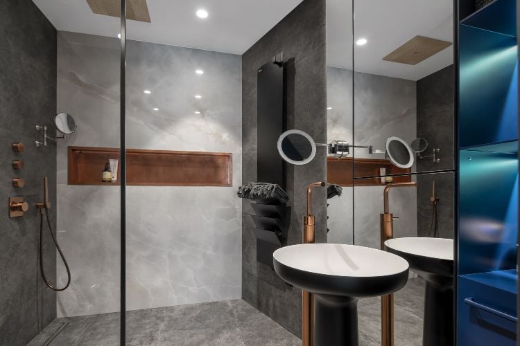 badezimmer spiegel design sanitärkeramik blaue regale tücher kupfer wasserhahn rund waschbecken duschkabine marmor effekt