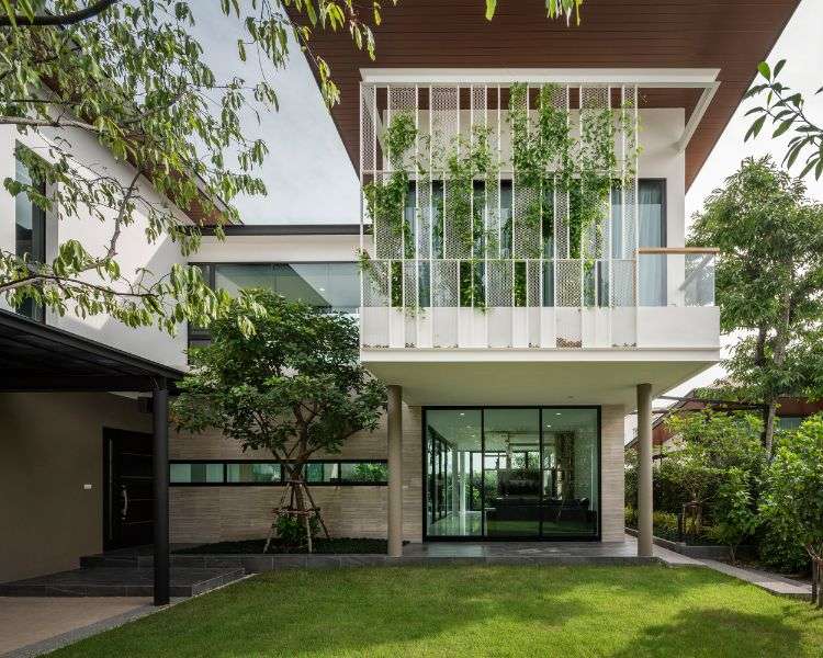 begrünte fassade designer haus moderne architektur glas terrasse natürliche umgebung bäume rasen wachsblume