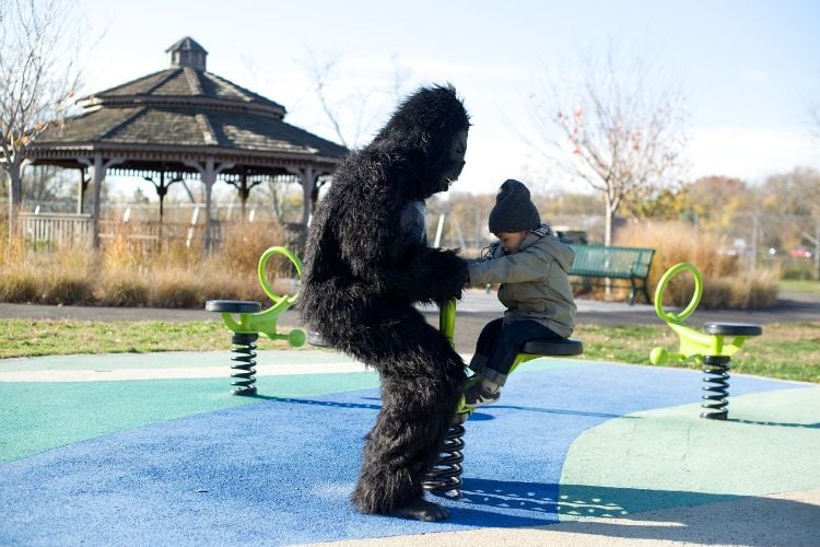 gorilla kostüm kind schaukeln amüsieren park sonnig tag