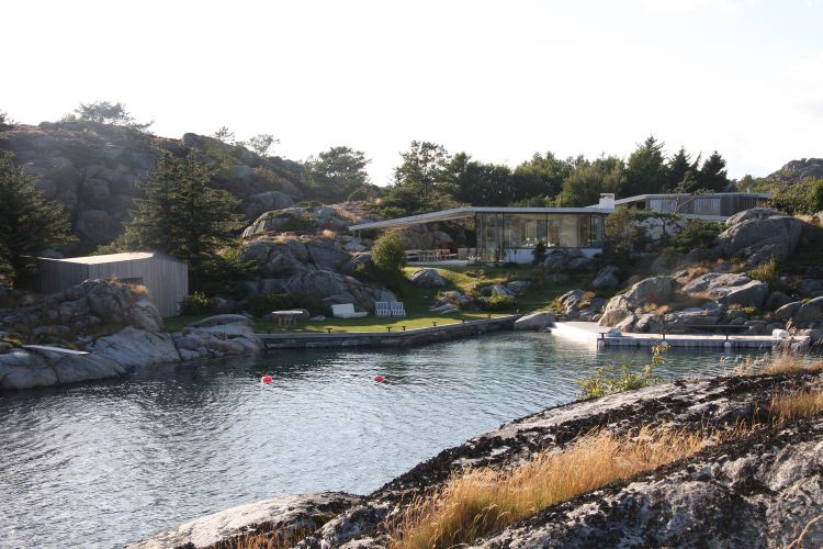 haus mit pultdach fjordhaus design felsen landschaft umgebung abendsonne vorderansicht