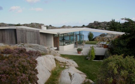 haus mit pultdach fjordhaus design felsen landschaft umgebung außenbereich gartenmöbel schräges dach aussicht abendsonne