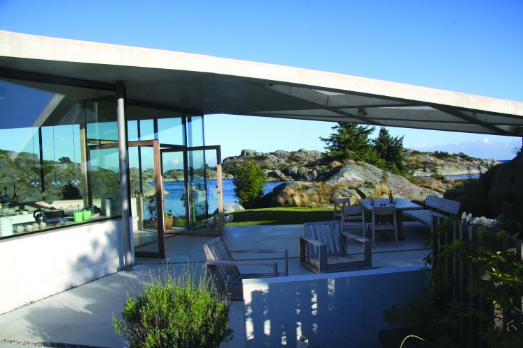 haus mit pultdach fjordhaus design felsen landschaft umgebung außenbereich gartenmöbel schräges dach aussicht