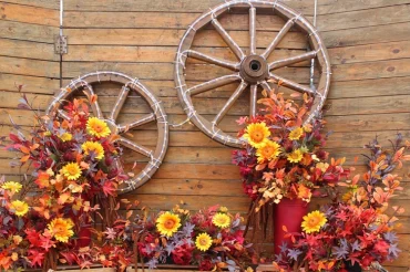 Herbstdeko mit Wagenrad und Lichterkette für Romantik am Abend
