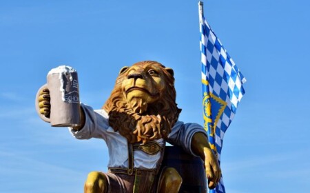 oktoberfest spiele löwe figur statue bierkrug fahne blau himmel