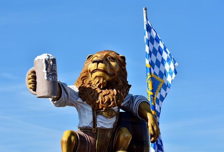 oktoberfest spiele löwe figur statue bierkrug fahne blau himmel