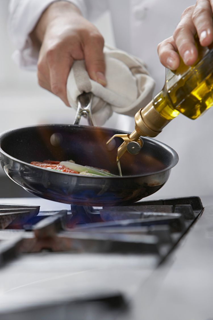 olivenöl zum braten nehmen glasflasche pfanne gießen gas kochplatte gemüse koch