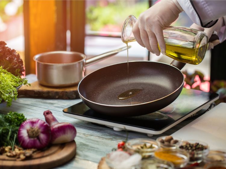 olivenöl zum braten nehmen glasflasche pfanne gießen kochplatte gemüse gewürze koch