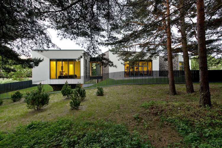 Einfamilienhaus am Hang transparenter Metallzaun Pinienwald