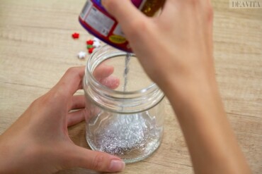 Silbernes Glitter ins Glas geben Schneekugel basteln