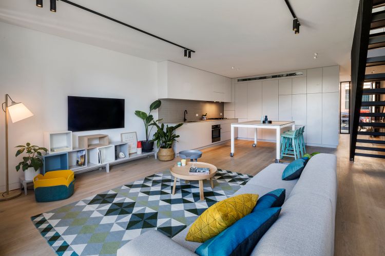 haus mit holzfassade holzverkleidung treppe innenraum wohnzimmer rerto design geometrische formen teppich sofa einbauküche
