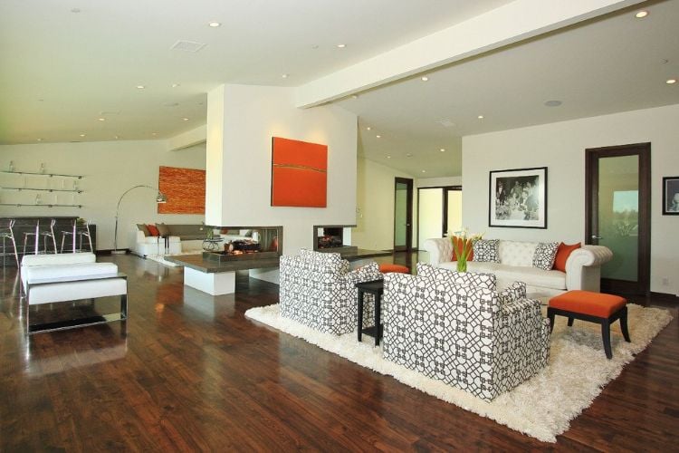 kamin mitten im raum gestalten wohnzimmer feuerstelle künstlerisch art weiß farbe orange design doppelt funktion