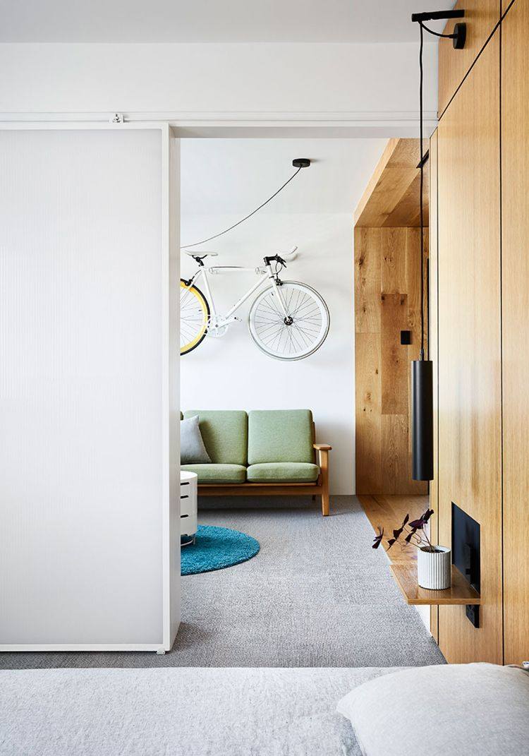 mikro wohnung einrichten minimalistisch design 70er jahre stil holzverkleidung fahrrad hängen retro sofa pendelleuchte pflanze
