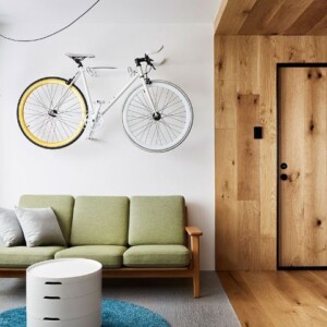 mikro wohnung einrichten minimalistisch design 70er jahre stil holzverkleidung fahrrad hängen retro sofa rund tisch teppich