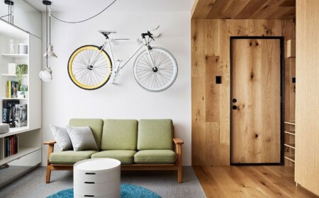 mikro wohnung einrichten minimalistisch design 70er jahre stil holzverkleidung fahrrad hängen retro sofa rund tisch teppich