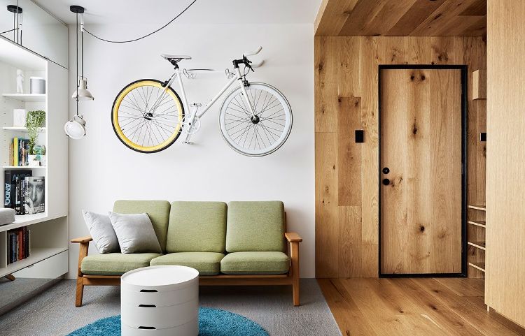 mikro wohnung einrichten minimalistisch design 70er jahre stil holzverkleidung fahrrad hängen retro sofa rund tisch teppich