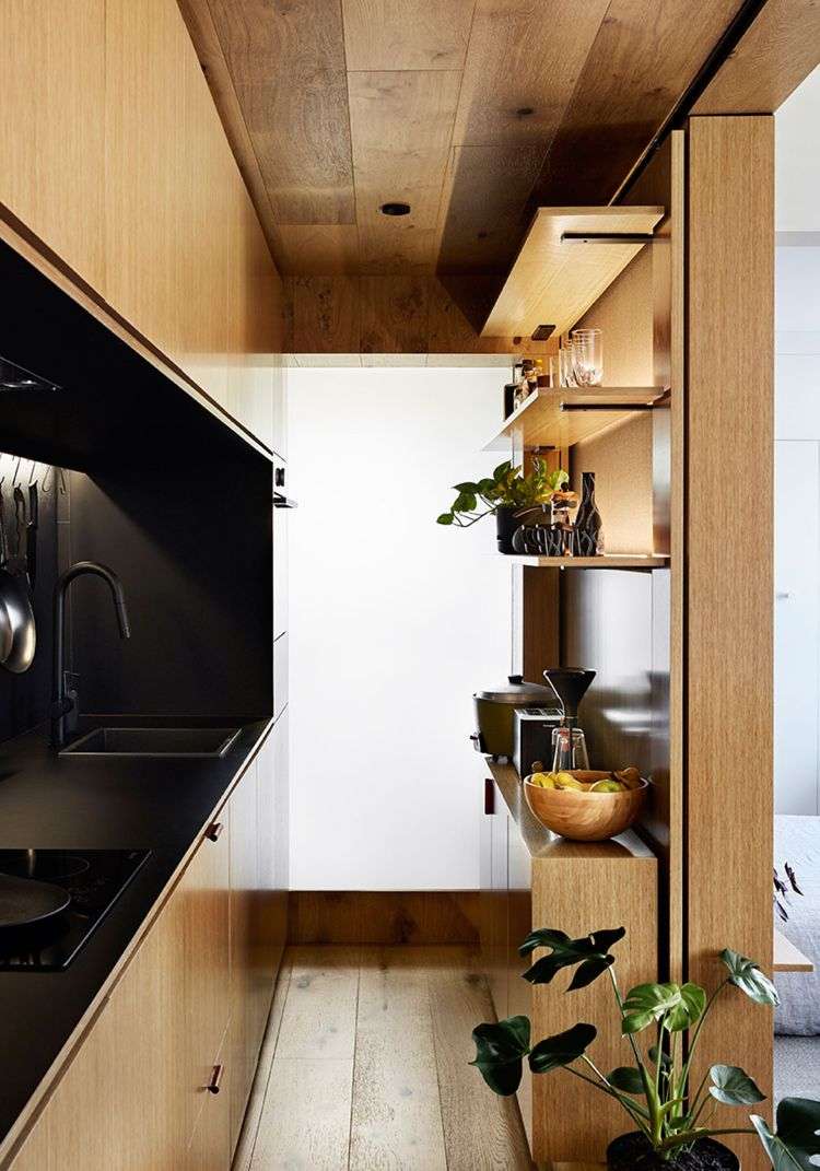 mikro wohnung einrichten minimalistisch design 70er jahre stil holzverkleidung küche schwarz marmor integriert arbeitsplatte spülbecken