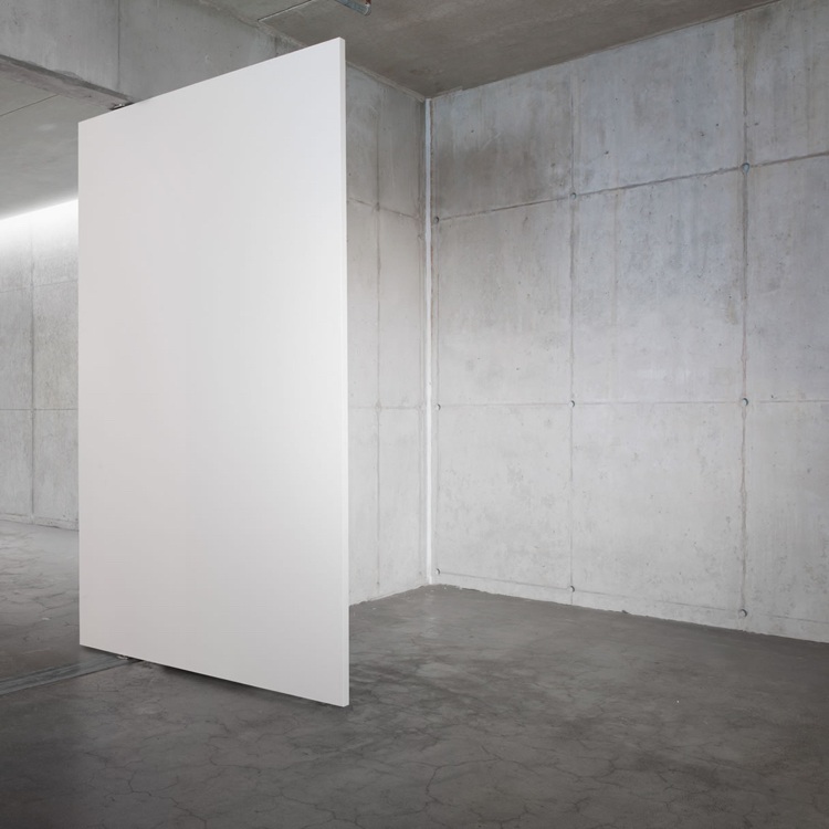 moderne Pendeltür weiß lackiert minimalistisch Sichtbetonwand