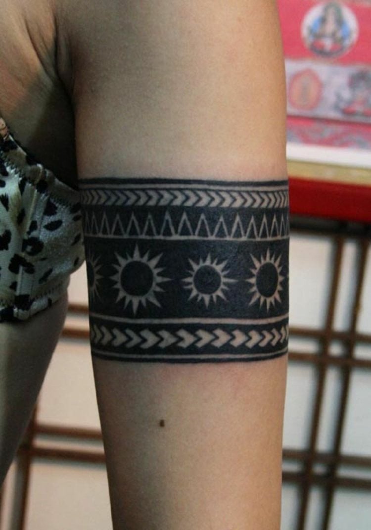 tattoo armband frau oberarm breit auffällig geometrische figuren sonne symbol
