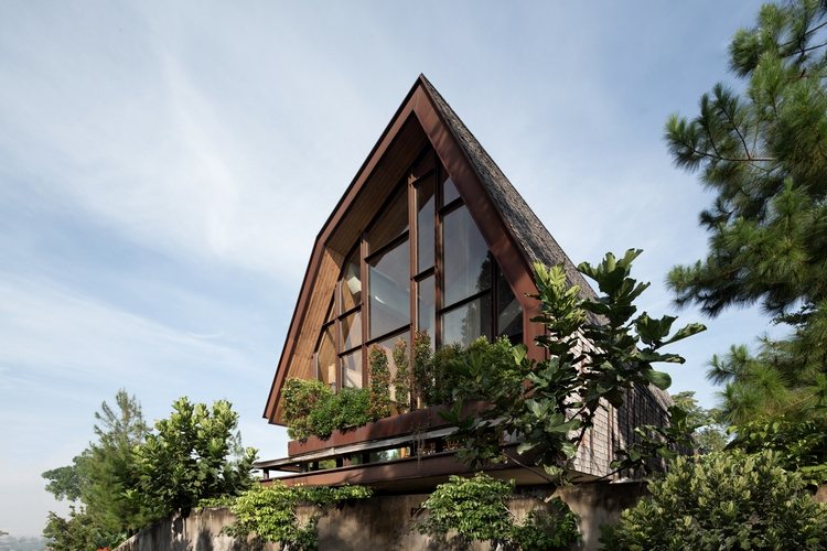 ferienhaus aus holz wald perfektes refugium wochenendhaus holzverkleidung glasfenster grüne bäume himmel