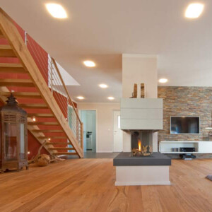 gemütliches Haus mit Kamin als Raumteiler Holztreppe Steinwand Parkettboden