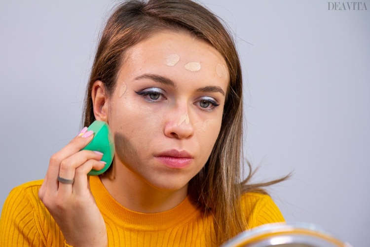 ie Foundation mit dem Make-up-Schwamm auf dem Gesicht verteilen