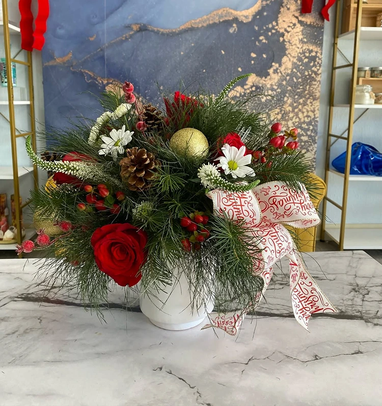 kombination aus roten rosen weißen blüten zapfen und frischem nadelgrün