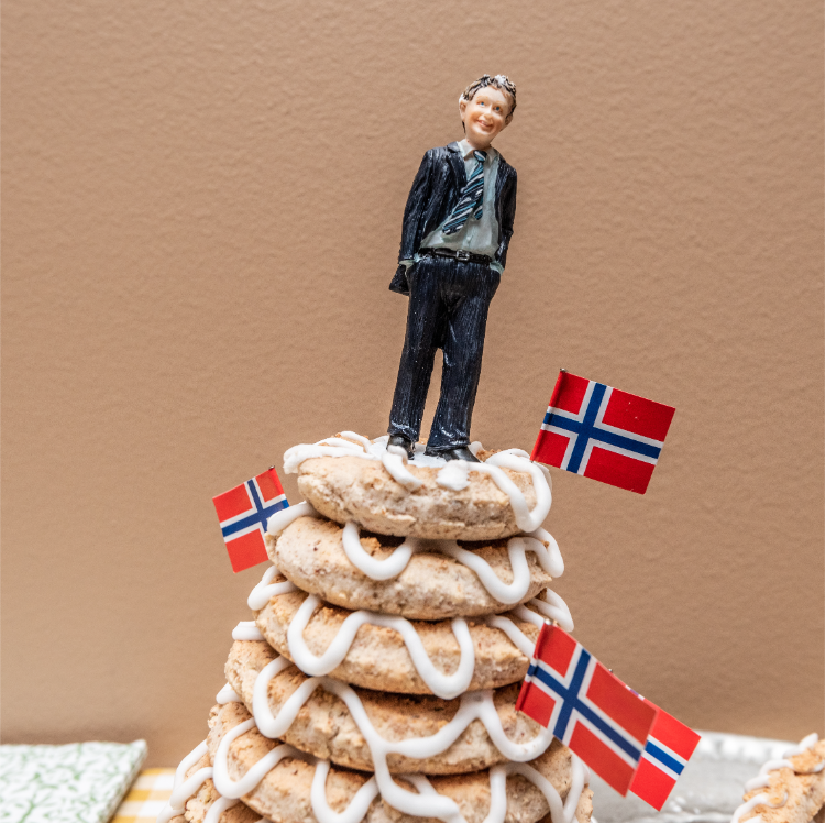 kransekage, turmkuchen mit der figur eines jungen mannes auf der obersten und norwegischen flagge.