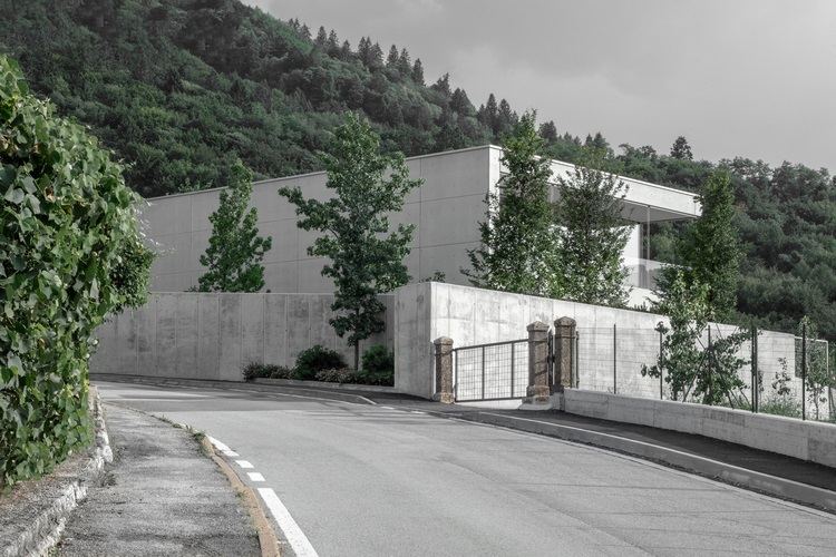 sichtbeton haus casa mf große glasfenster modernes minimalistisches design betonmauer wald eingangstor straße