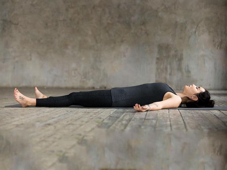 yoga nidra zum einschlafen praktische einschlafübungen besseren schlaf tiefentspannung frau studio liegen schlafen matte holzboden