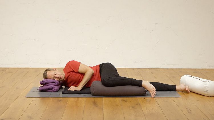 yoga nidra zum einschlafen praktische einschlafübungen besseren schlaf tiefentspannung mann studio liegen schlafen kissen matte holzboden
