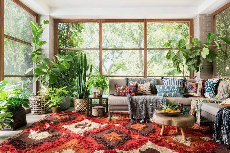 couch vor fenster ecksofa wohnzimmer bunt kakteen und sukkulenten webteppich geometrische formen holzrahmen bohemien stil