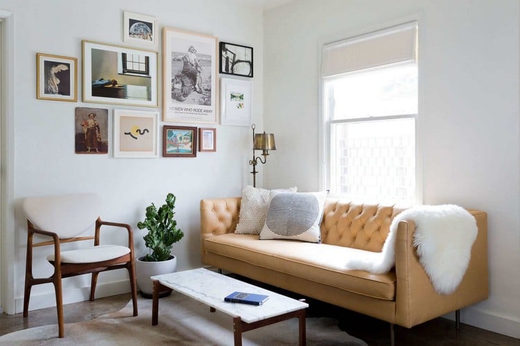 couch vor fenster gelb ledercouch holzstuhl zimmer bilder wand marmor tisch tageslicht verdunkelungsrollo klassisch weiß