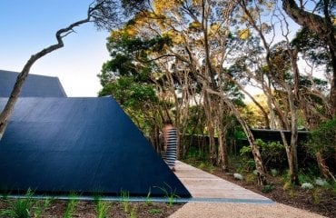 design ferienhaus schrägdach küstenwald moderne berghütte außergewöhnliche form natur moonah bäume