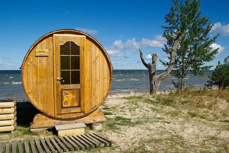 outdoor sauna bauen ideen designs entspannungsbereich im freien liegestühle baum blüten holz saunahäuschen rund küste meer