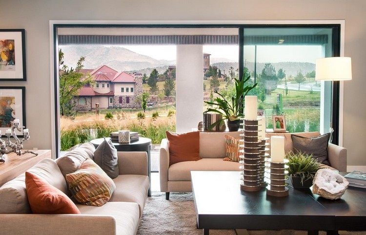 sofa vor fenster aufstellen wohnzimmer stilvoll couch doppelt einrichten holztisch dekorieren kerzen pflanze ferienhaus malereien terrasse