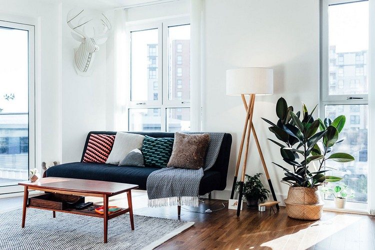 sofa vor fenster aufstellen wohnzimmer stilvoll couch laminatboden couchtisch sofatisch kissen bunt retro gummibaum