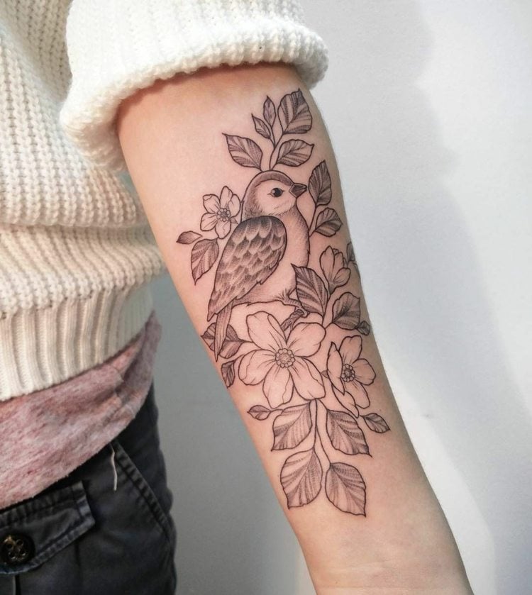 Damen Vogel Tattoo mit Blumen auf dem Unterarm