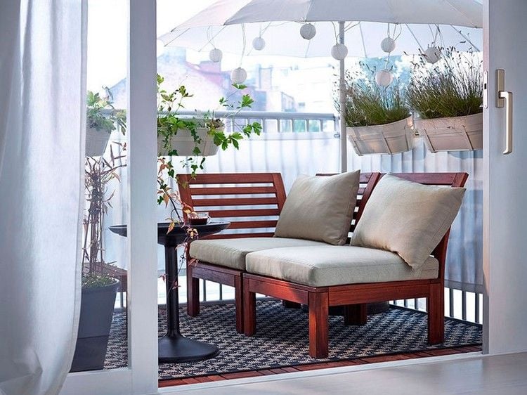 enge terrasse mit couch teppich pflanzen schirm und tisch