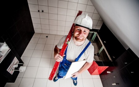 handwerker mit fliese in der hand im badezimmer lächeln