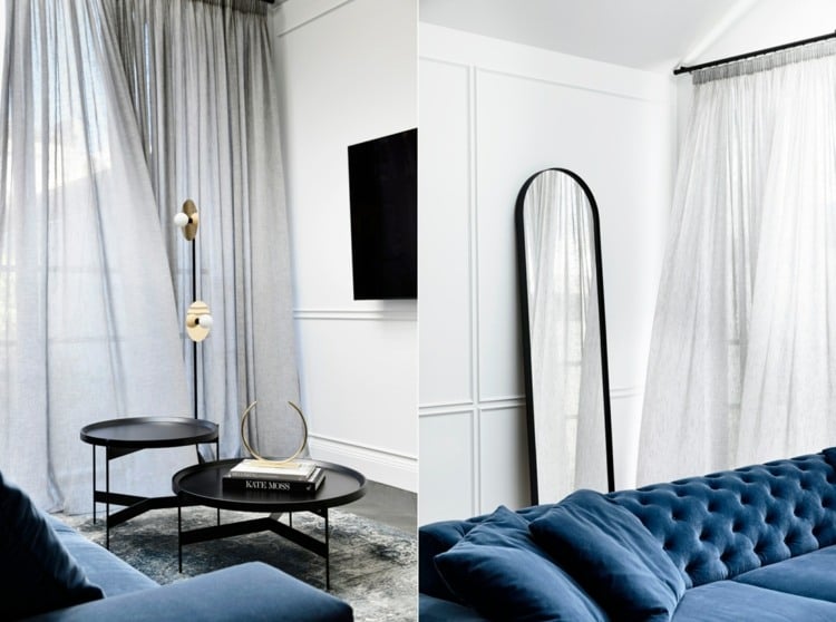 helles Wohnzimmer mit blauem Sofa und weißer Wandverkleidung