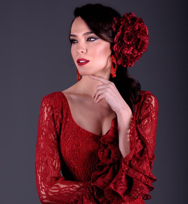 hübsche Spanierin mit dunklem Haar und rotem Kleid Blumenschmuck seitlich gesteckt