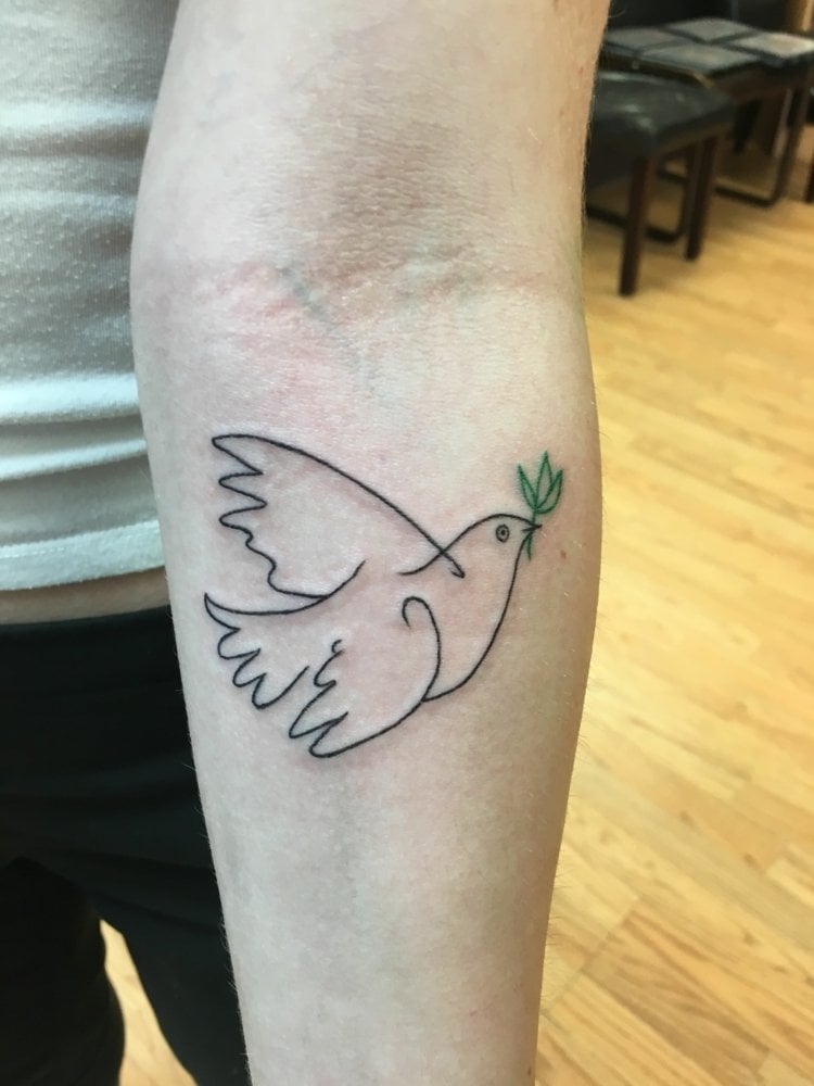 minimalistisches Vogel Tattoo mit grünem Zweig und Friedenstaube
