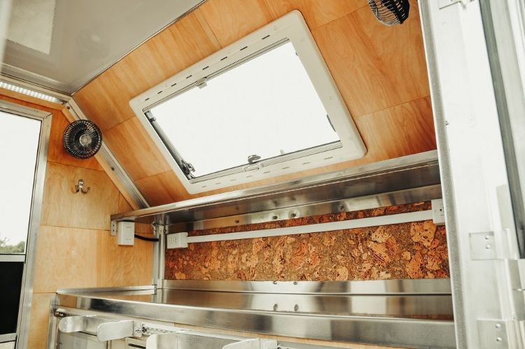 moderner camping anhänger kompakt wohnmobil innenraum kochecke küchenrückwand aus kork