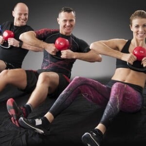 männer und frauen am crossfit training mit kugelhanteln