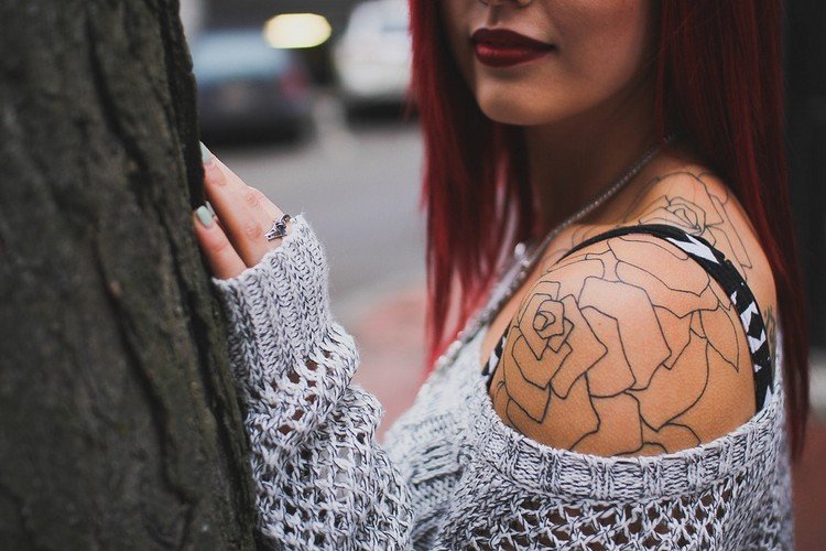 schulter tattoo rose tätowierung frau pullover kombinieren draußen am baum