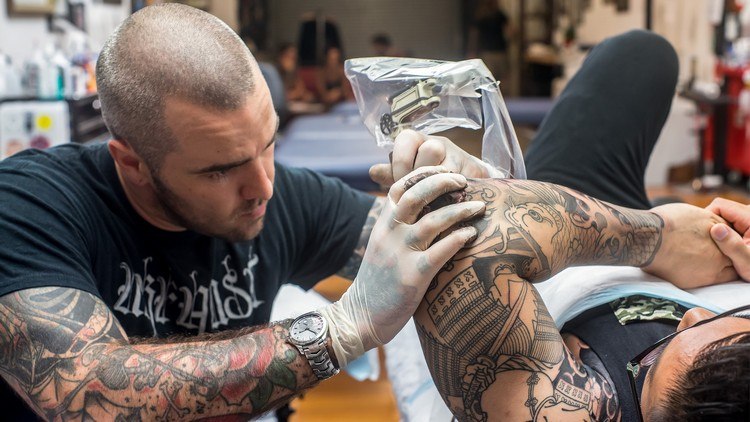 tattoo künstler am arbeiten oberarm tätowieren im studio