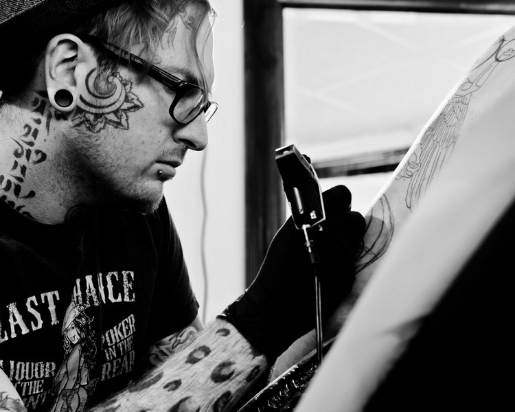 tattoo künstler mit tätowiermaschine in der hand