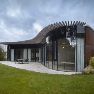 vorderseite mit gartenmöbeln im innenhof glastüren und begrüntes dach mit pergola