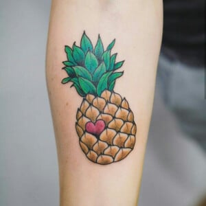 Ananas Tattoo mit Herz am Unterarm bunt